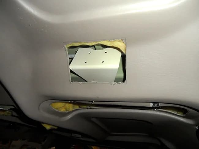 Bracket installed on forward carry-through spar straddles cabin roof stiffener